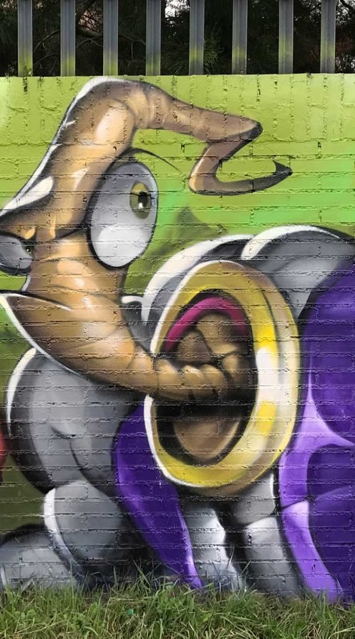 Mural graffiti de Earthworm Jim con raygun sobre fondo verde neón