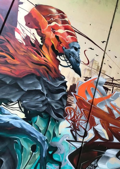 Graffiti de faraón egipcio con calavera y llamas en mural urbano