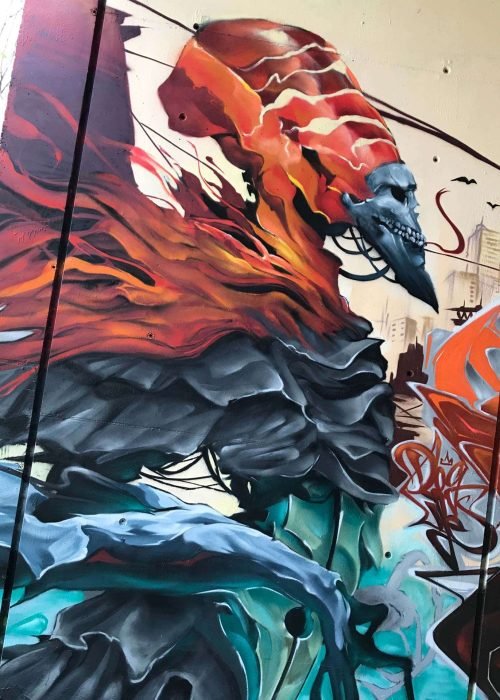 Graffiti de faraón egipcio con calavera y llamas en mural urbano