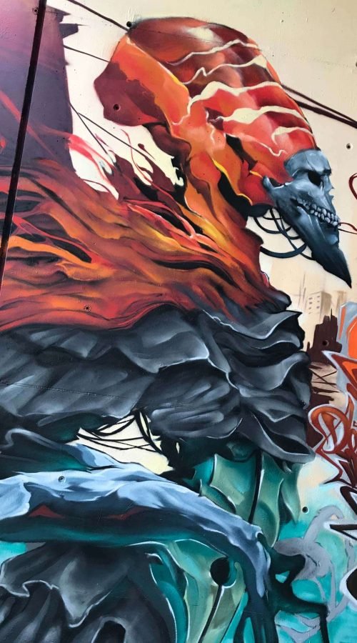 Graffiti de faraón egipcio con calavera y llamas en mural urbano