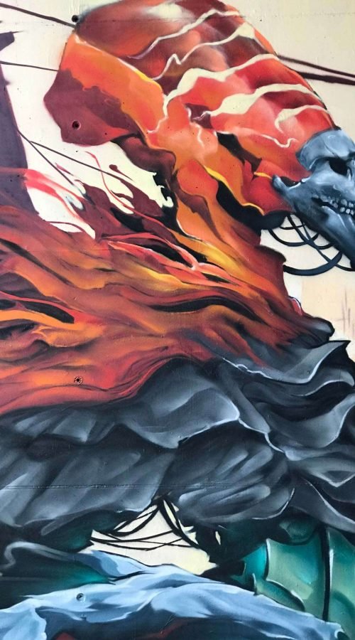 Graffiti de faraón egipcio con calavera y llamas en mural urbano