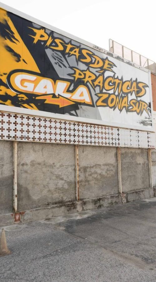 Graffiti con tráiler y texto en vallas publicitarias de Autoescuelas Gala