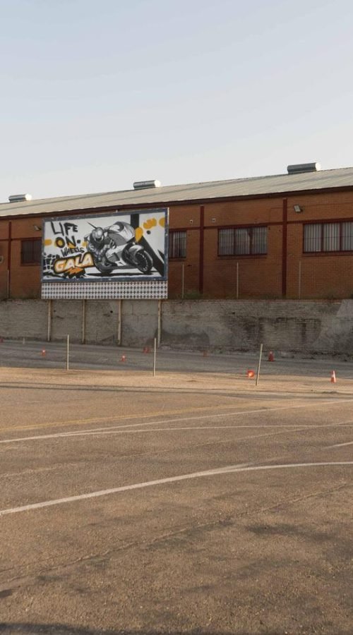 Graffiti con tráiler y texto en vallas publicitarias de Autoescuelas Gala