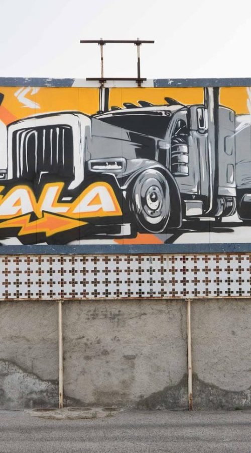 Graffiti con tráiler y texto en vallas publicitarias de Autoescuelas Gala