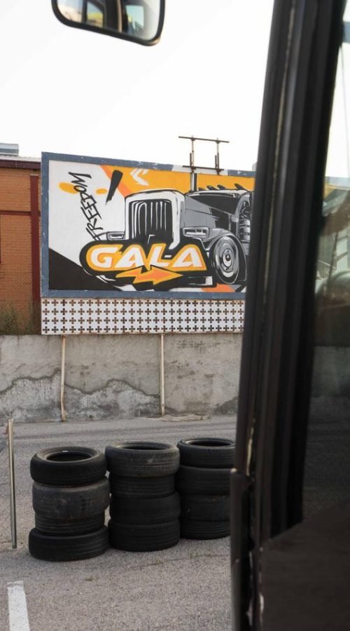 Graffiti con tráiler y texto en vallas publicitarias de Autoescuelas Gala