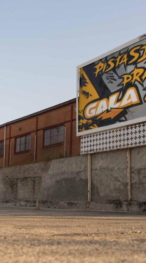 Graffiti con tráiler y texto en vallas publicitarias de Autoescuelas Gala