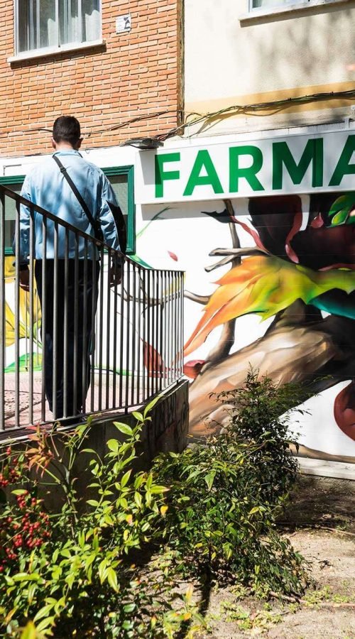 Mural con ramas y hojas en fachada de Farmacia Parque9, graffiti para imagen de salud