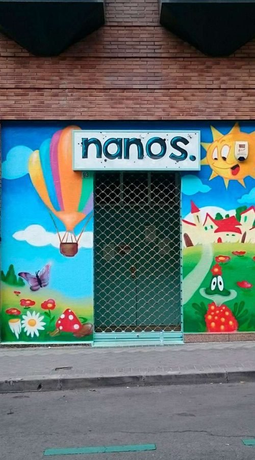 Mural infantil en guardería Nanos con globos, sol, campo y colores alegres