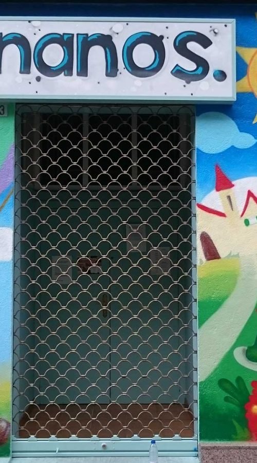 Mural infantil en guardería Nanos con globos, sol, campo y colores alegres