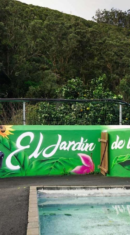 Mural exterior para hotel de mascotas en Tenerife con perro negro y rótulo El Jardín de las Mascotas