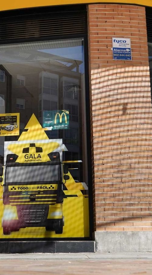 Moto deportiva amarilla y silueta urbana en mural para Gala Bravo Murillo, Madrid