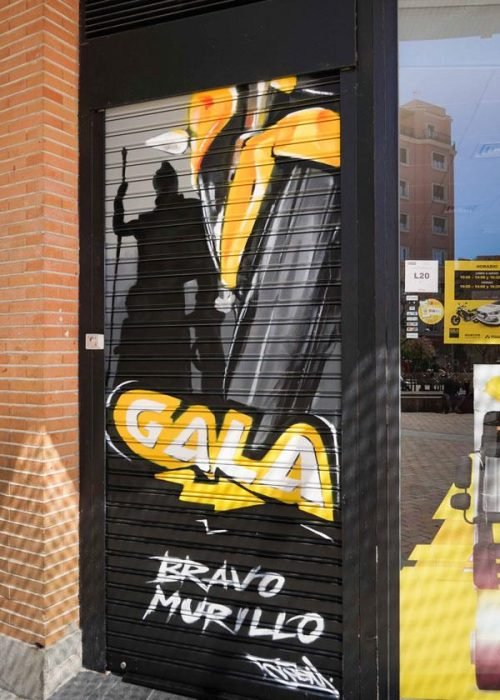 Moto deportiva amarilla y silueta urbana en mural para Gala Bravo Murillo, Madrid