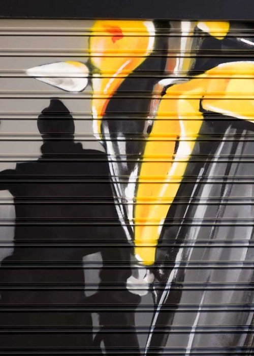 Moto deportiva amarilla y silueta urbana en mural para Gala Bravo Murillo, Madrid