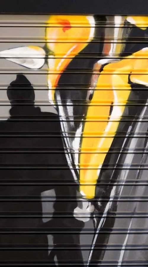 Moto deportiva amarilla y silueta urbana en mural para Gala Bravo Murillo, Madrid