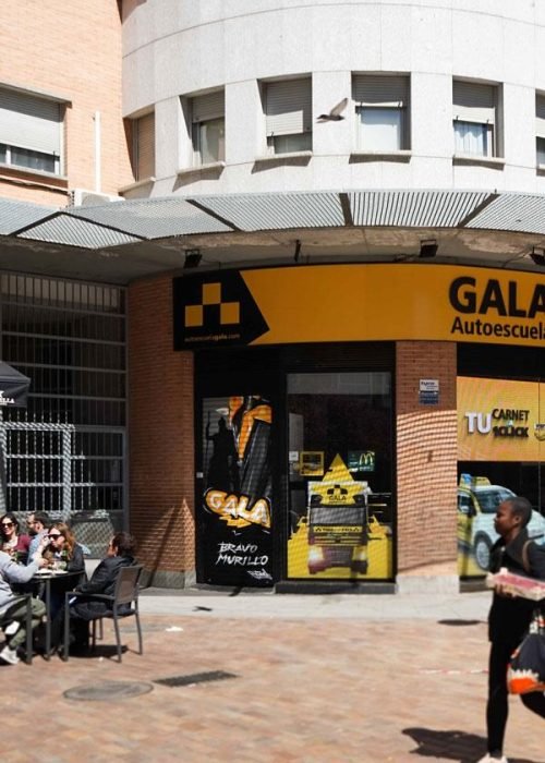 Moto deportiva amarilla y silueta urbana en mural para Gala Bravo Murillo, Madrid