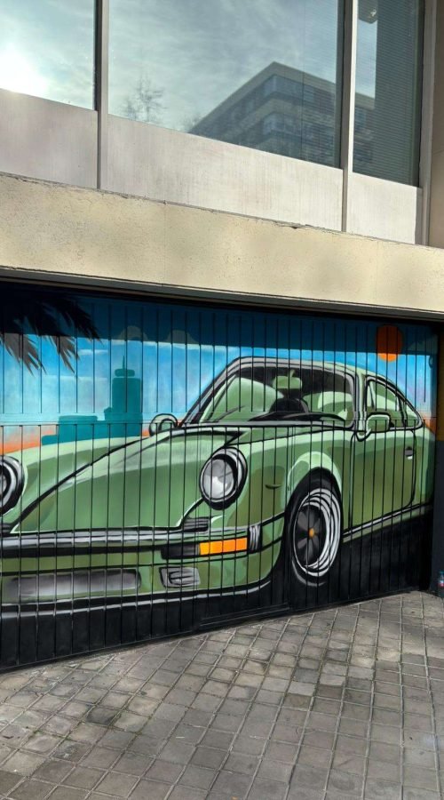 Vista frontal de cierre de garaje pintado con mural de coche clásico para comunidad de vecinos