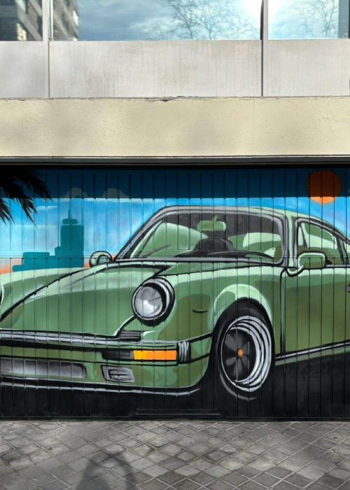 Graffiti mural de coche clásico verde en cierre de garaje para comunidad de vecinos