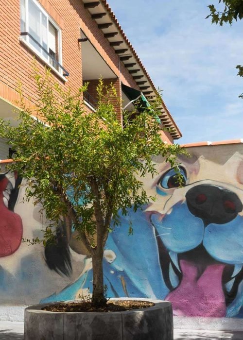 Mural con perros felices en fachada de clínica veterinaria en Toledo