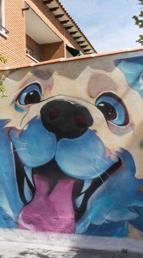 Mural con perros felices en fachada de clínica veterinaria en Toledo