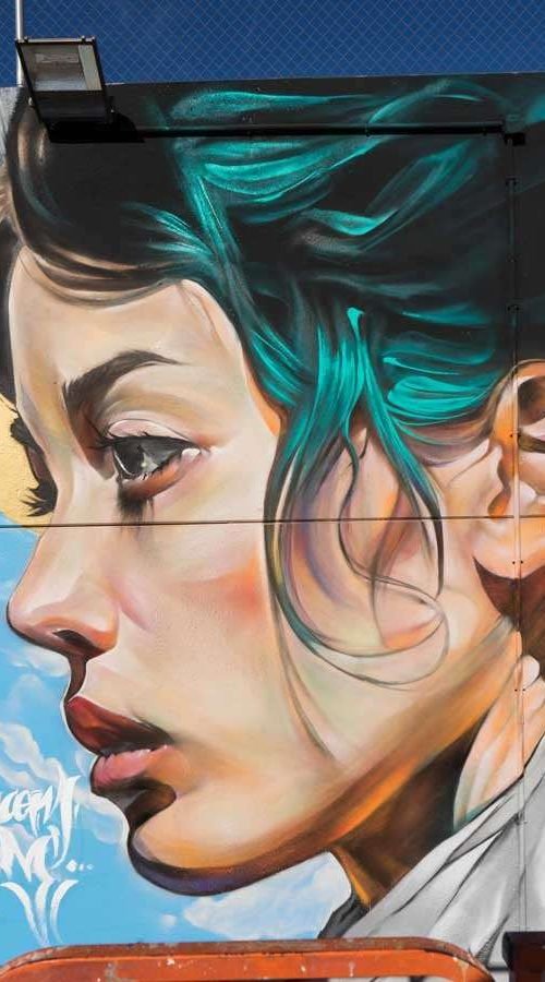 Retrato mural en fachada de edificio público en Godella, arte urbano profesional