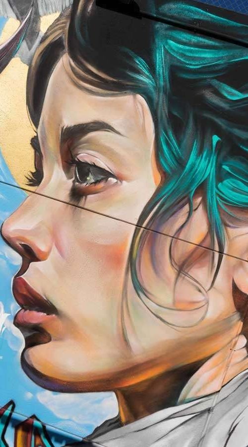 Retrato mural en fachada de edificio público en Godella, arte urbano profesional