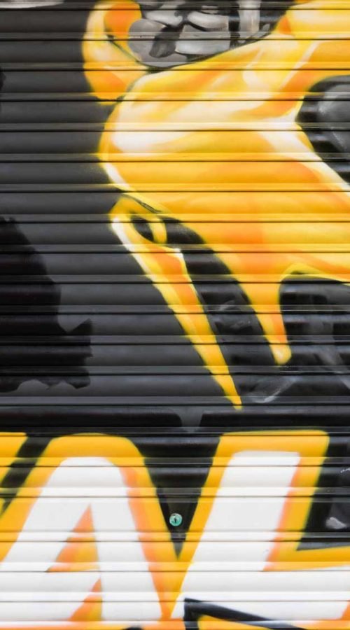 Cierre pintado de Autoescuela Gala con camión y moto en estilo urbano