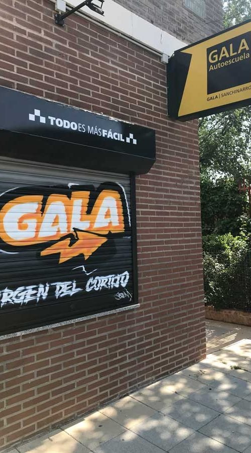 Cierres pintados con coche amarillo en Autoescuela Gala de Hortaleza (Virgen del Cortijo)