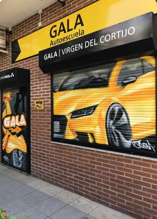 Cierres pintados con coche amarillo en Autoescuela Gala de Hortaleza (Virgen del Cortijo)
