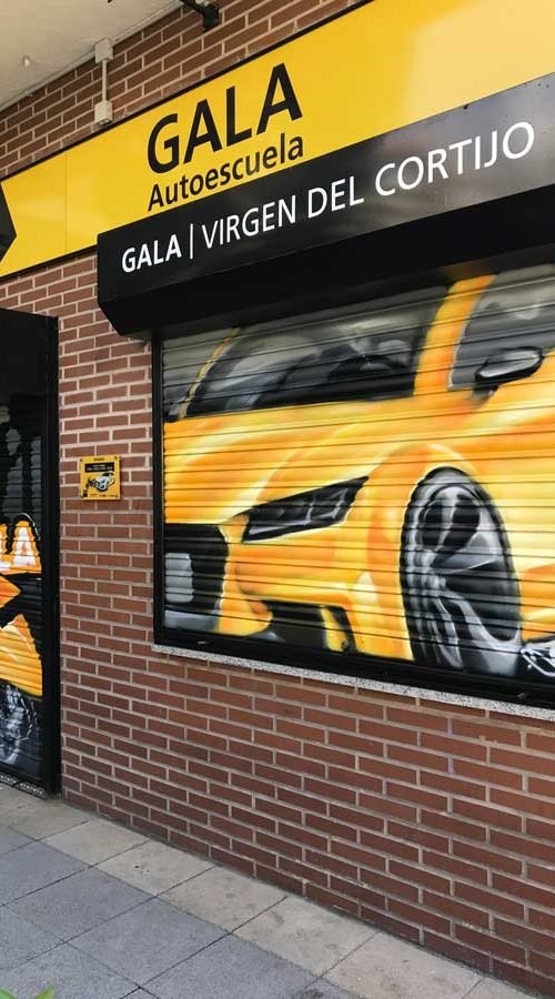 Cierres pintados con coche amarillo en Autoescuela Gala de Hortaleza (Virgen del Cortijo)