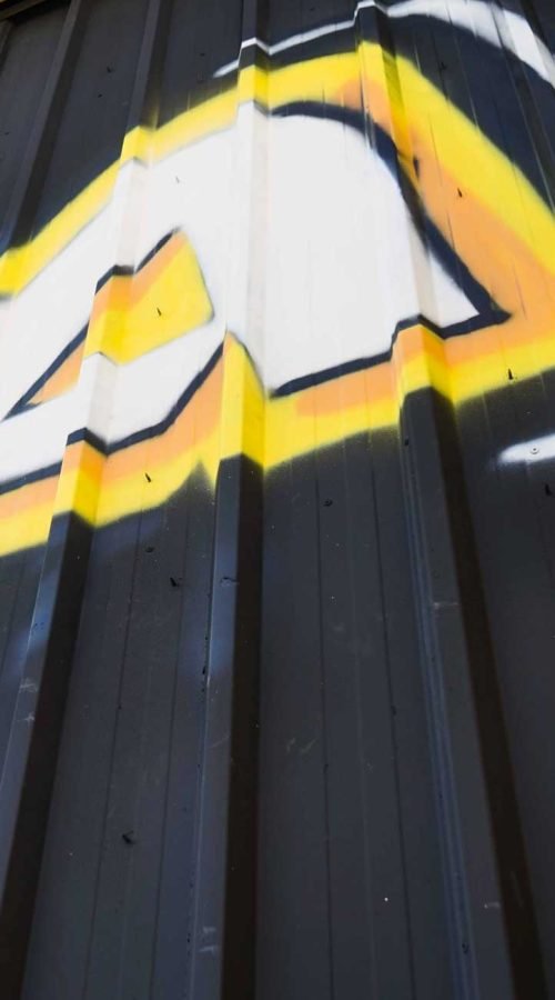 Fachada con graffiti de Autoescuela Gala en pistas de Sanchinarro