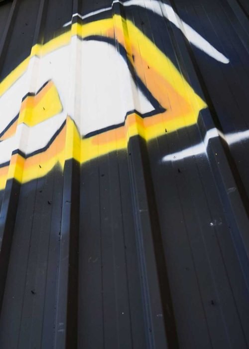 Fachada con graffiti de Autoescuela Gala en pistas de Sanchinarro