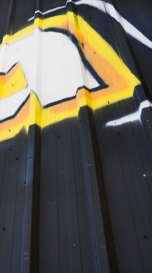 Fachada con graffiti de Autoescuela Gala en pistas de Sanchinarro