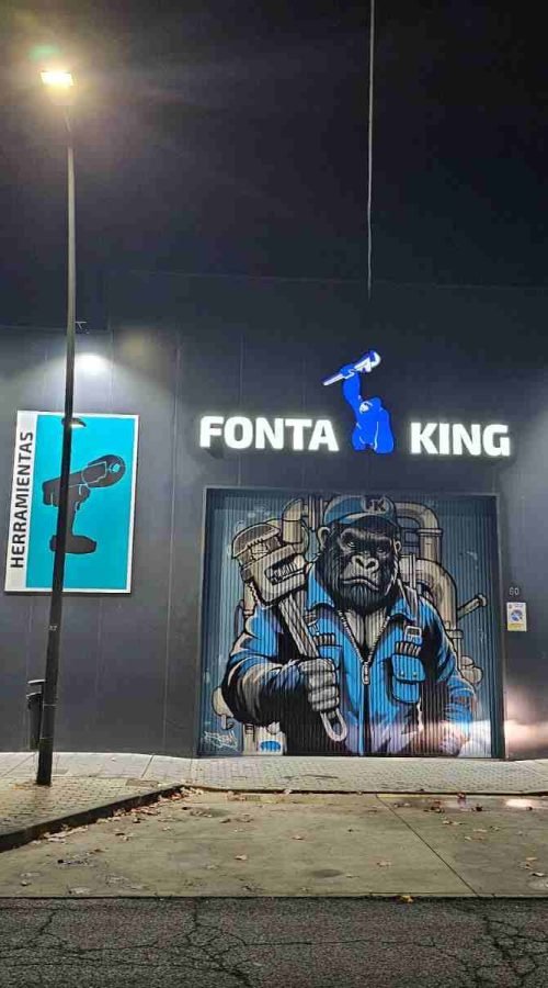 Fachada de negocio Fontaking terminada de noche con mural industrial y rotulación corporativa