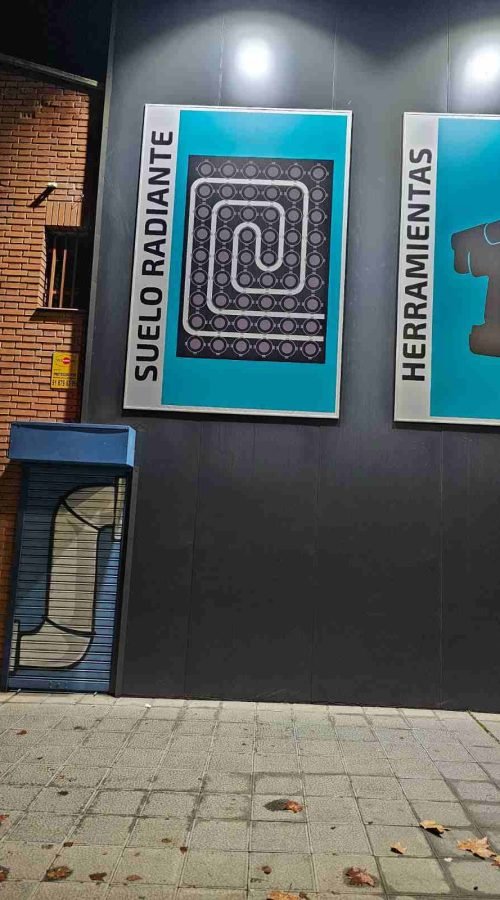 Detalle lateral de fachada industrial Fontaking con rótulos de suelo radiante y herramientas