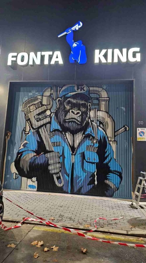 Graffiti corporativo en fachada de Fontaking con gorila uniformado y branding iluminado de noche