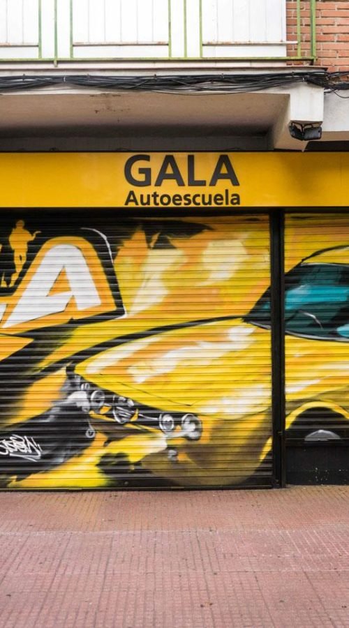 Cierre con mural de Rolls-Royce amarillo para Autoescuela Gala en estilo graffiti
