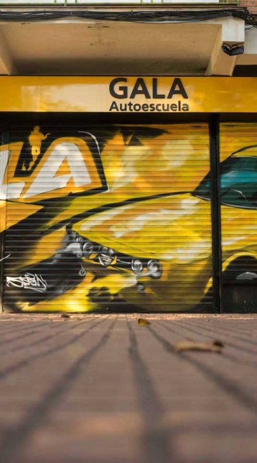 Cierre con mural de Rolls-Royce amarillo para Autoescuela Gala en estilo graffiti
