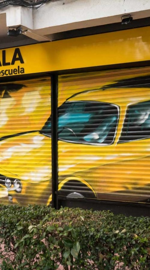 Cierre con mural de Rolls-Royce amarillo para Autoescuela Gala en estilo graffiti