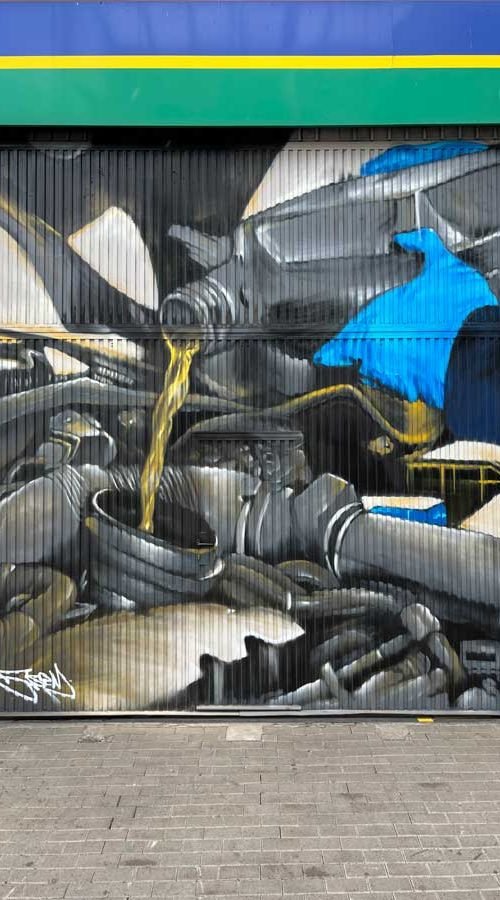 Mural mecánico realista en taller Euromaster Usera con motor y ruedas