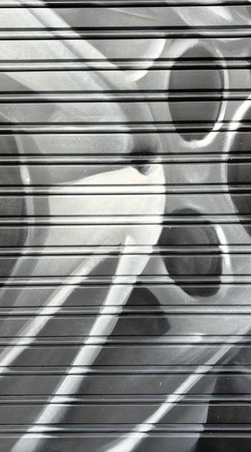 Graffiti de mecánica y engranajes en fachada de Euromaster Julián Camarillo