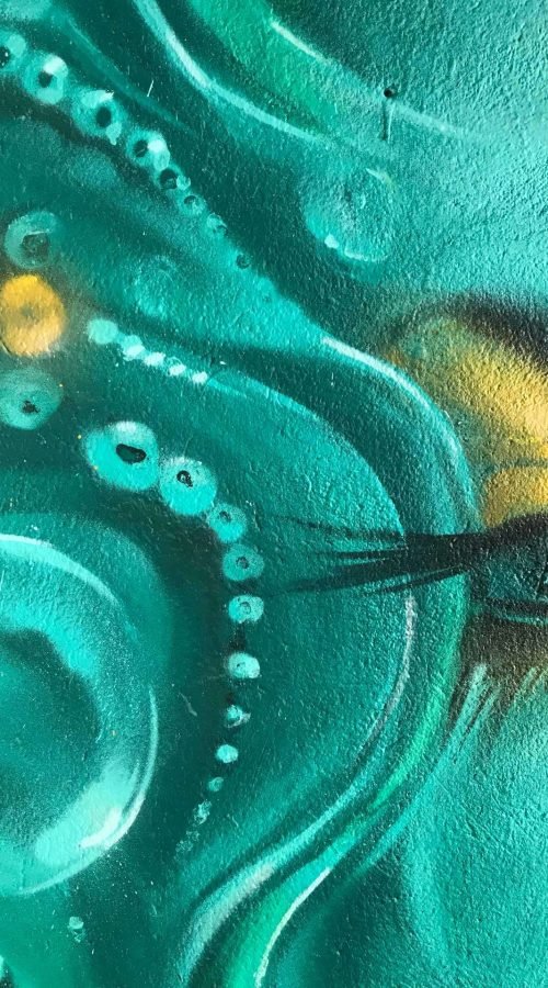 Mural urbano con rostro femenino turquesa en terraza interior