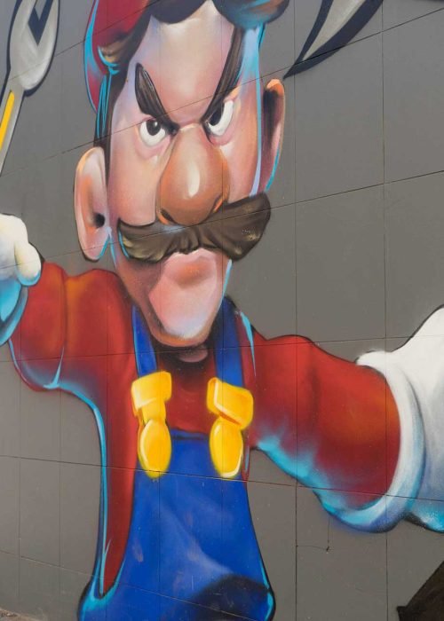 Mural para fontanería con personaje tipo Mario y herramientas, arte urbano comercial