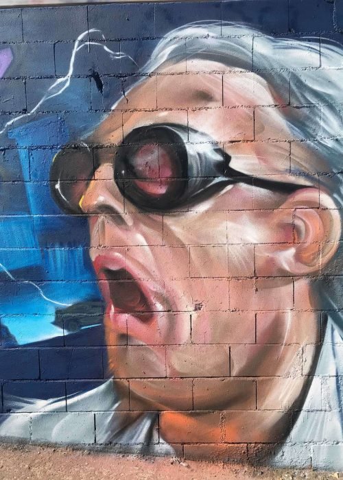 Mural graffiti de Marty McFly y el Delorean de Back to the Future con colores vivos y estilo ochentero