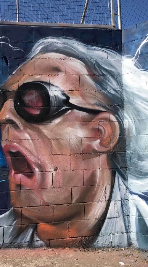 Mural graffiti de Marty McFly y el Delorean de Back to the Future con colores vivos y estilo ochentero