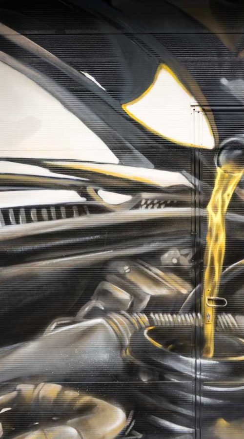 Mural mecánico realista en taller Euromaster Usera con motor y ruedas