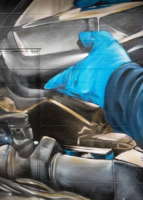 Mural mecánico realista en taller Euromaster Usera con motor y ruedas