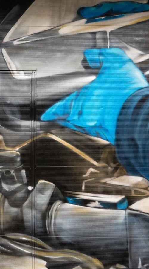 Mural mecánico realista en taller Euromaster Usera con motor y ruedas