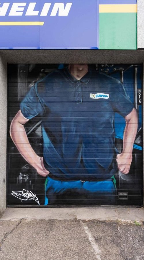 Mural mecánico realista en taller Euromaster Usera con motor y ruedas