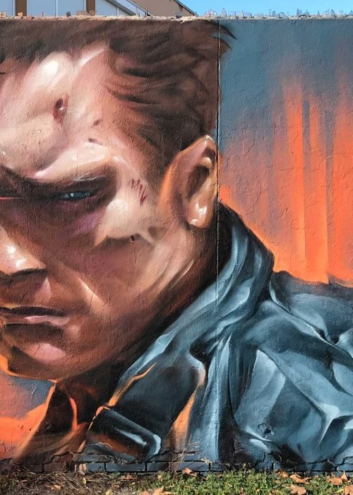 Graffiti hiperrealista de Terminator sobre fondo naranja y azul