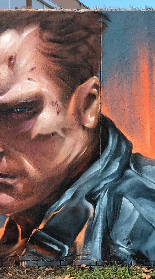 Graffiti hiperrealista de Terminator sobre fondo naranja y azul